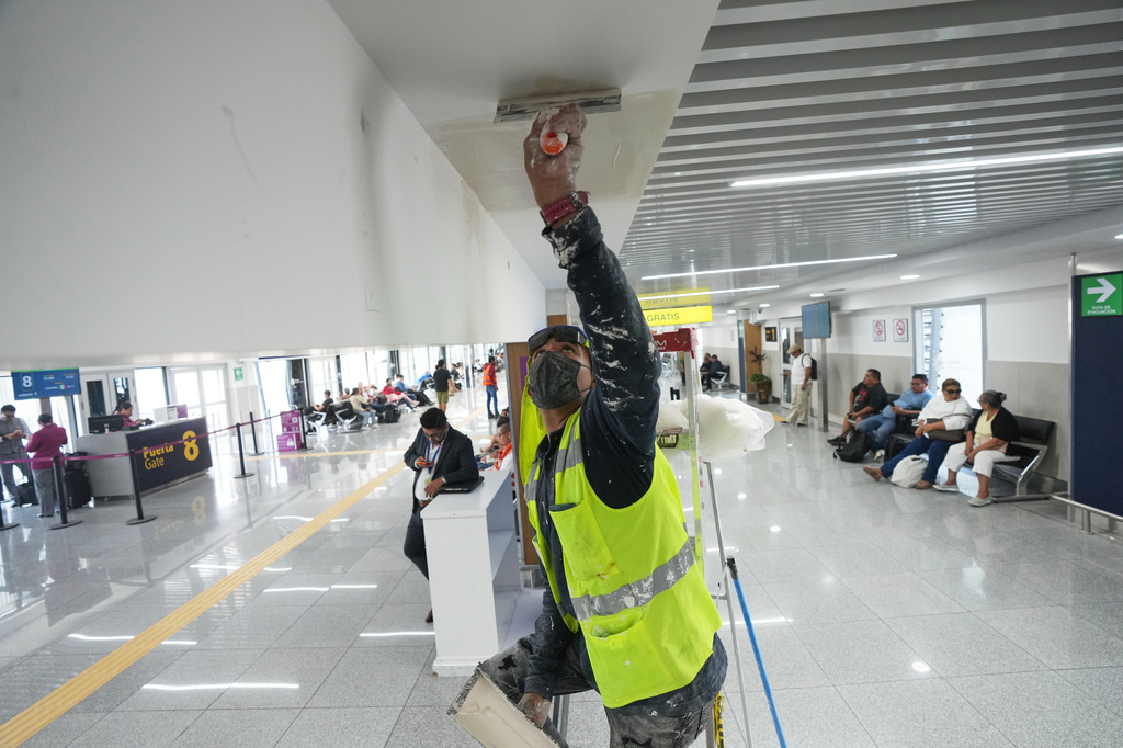 A worker paints the ceiling in Terminal 1 during a guided media tour of the renovation work at Benito Juárez International Airport, in preparation for the 2026 World Cup in Mexico City, on Tuesday, May 19, 2026. (AP Photo/Fernando Llano)