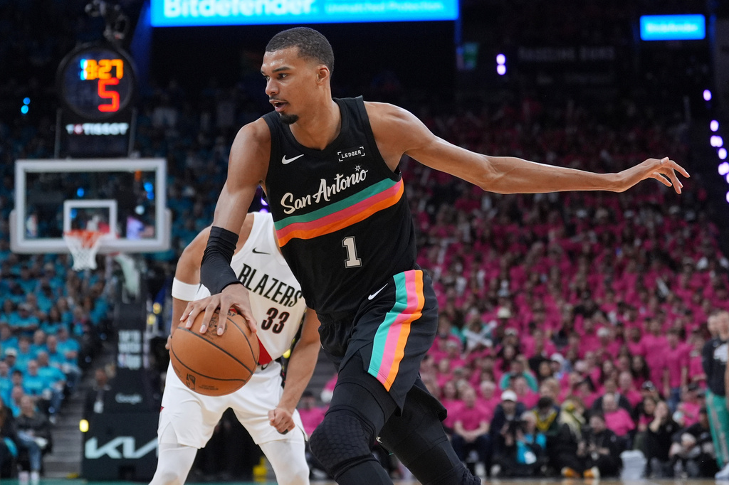 San Antonio Spurs forward Victor Wembanyama (1) drives past Portland Trail Blazers forward Toumani Camara (33) during the second half in Game 1 of a first-round NBA playoffs basketball series in San Antonio, Sunday, April 19, 2026. (AP Photo/Eric Gay)