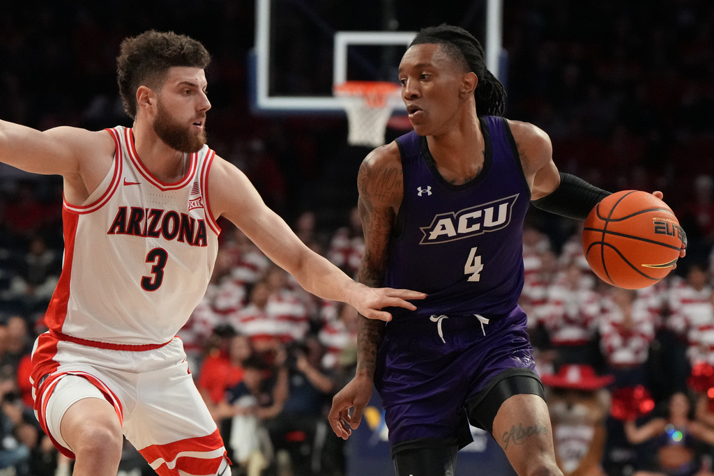 Abilene Christian guard Rich Smith shields the ball from Arizona guard Anthony Dell'Orso (3) during the first half of an NCAA college basketball game, Tuesday, Dec. 16, 2025, in Tucson, Ariz. (AP Photo/Rick Scuteri)