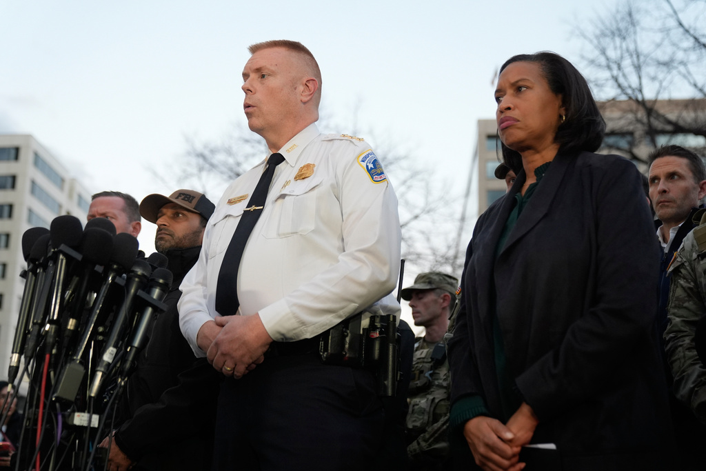 Flanked by District of Columbia Mayor Muriel Bowser, right, Executive Assistant Chief, Metropolitan Police Department Jeffery Carroll speaks during a press conference following the shooting of two National Guard soldiers near the White House Wednesday, Nov. 26, 2025, in Washington. (AP Photo/Mark Schiefelbein)