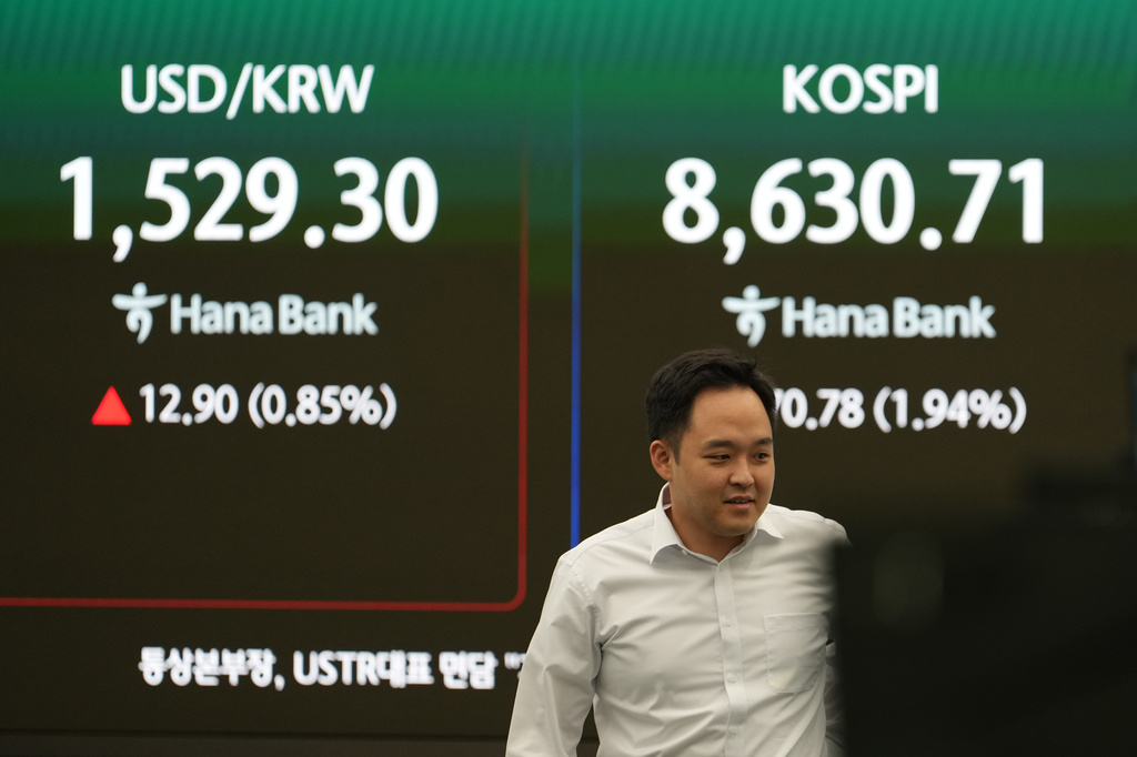 A dealer walks past near the screens showing the Korea Composite Stock Price Index (KOSPI) and the foreign exchange rate between U.S. dollar and South Korean won at a dealing room of Hana Bank in Seoul, South Korea, Thursday, June 4, 2026. (AP Photo/Lee Jin-man)
