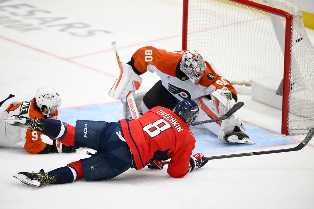Washington Capitals left wing Alex Ovechkin (8) scores a goal past Philadelphia Flyers goaltender Dan Vladar (80) and defenseman Jamie Drysdale (9) during the third period of an NHL hockey game, Tuesday, March 31, 2026, in Washington. (AP Photo/Nick Wass)