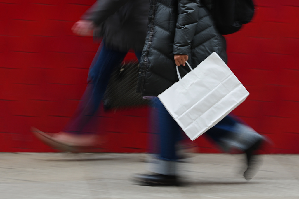 FILE - A person carries a shopping bag in Philadelphia, Wednesday, Dec. 10, 2025. (AP Photo/Matt Rourke, File)