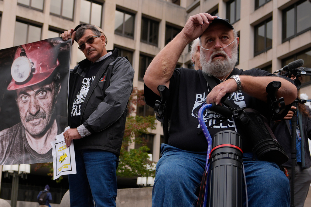 Arvin Hanshaw, of Summersville, W.Va., left, and Randy Lawrence, president of the Kanawha County Black Lung Association, right, put their hats back on after praying during a rally protesting the government's failure to limit exposure to deadly silica in mines, outside the U.S. Department of Labor, Oct. 14, 2025, in Washington. (AP Photo/Carolyn Kaster)