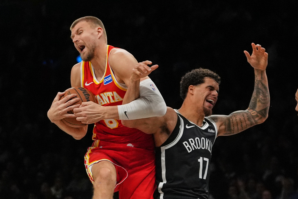 Atlanta Hawks' Kristaps Porziņģis (8) fights for control of the ball with Brooklyn Nets' Michael Porter Jr. (17) during the second half of an NBA basketball game Wednesday, Oct. 29, 2025, at Barclays Center in New York. (AP Photo/Frank Franklin II)