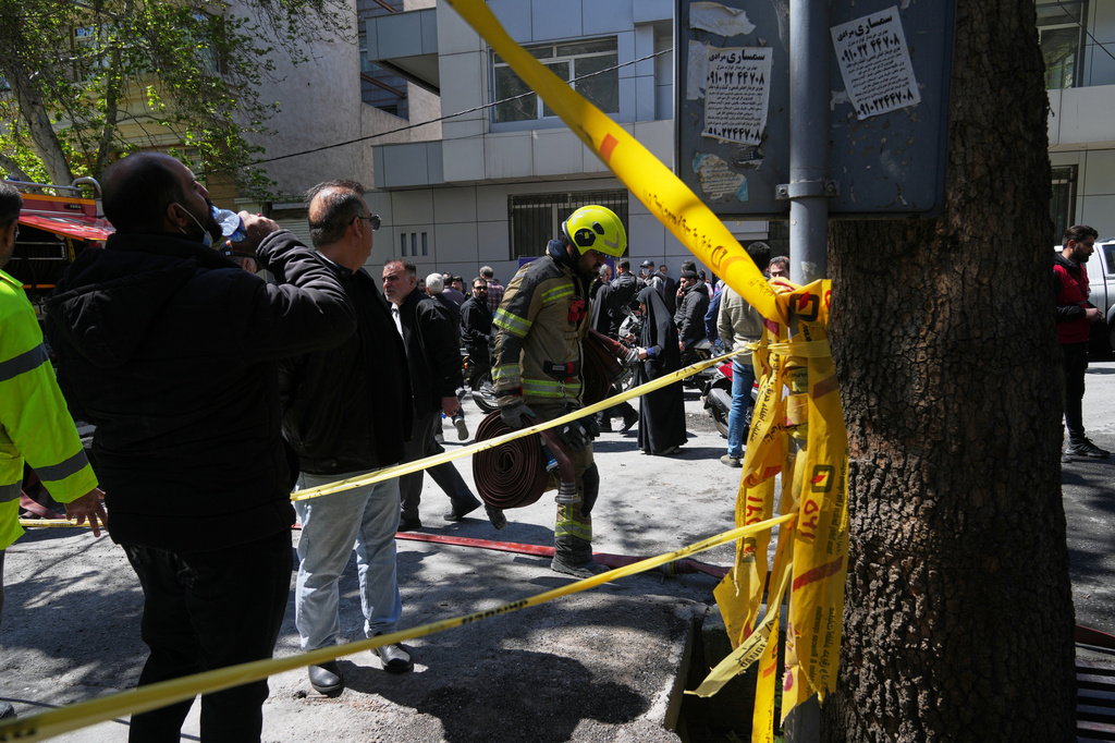 A first responder leaves the site of a strike that, according to a security official at the scene, destroyed half of the Khorasaniha Synagogue and nearby residential buildings in Tehran, Iran, Tuesday, April 7, 2026. (AP Photo/Francisco Seco)