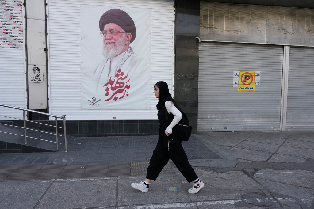 A woman walks past a poster of the late Iranian Supreme Leader Ayatollah Ali Khamenei in downtown Tehran, Iran, Sunday, April 5, 2026. (AP Photo/Vahid Salemi)