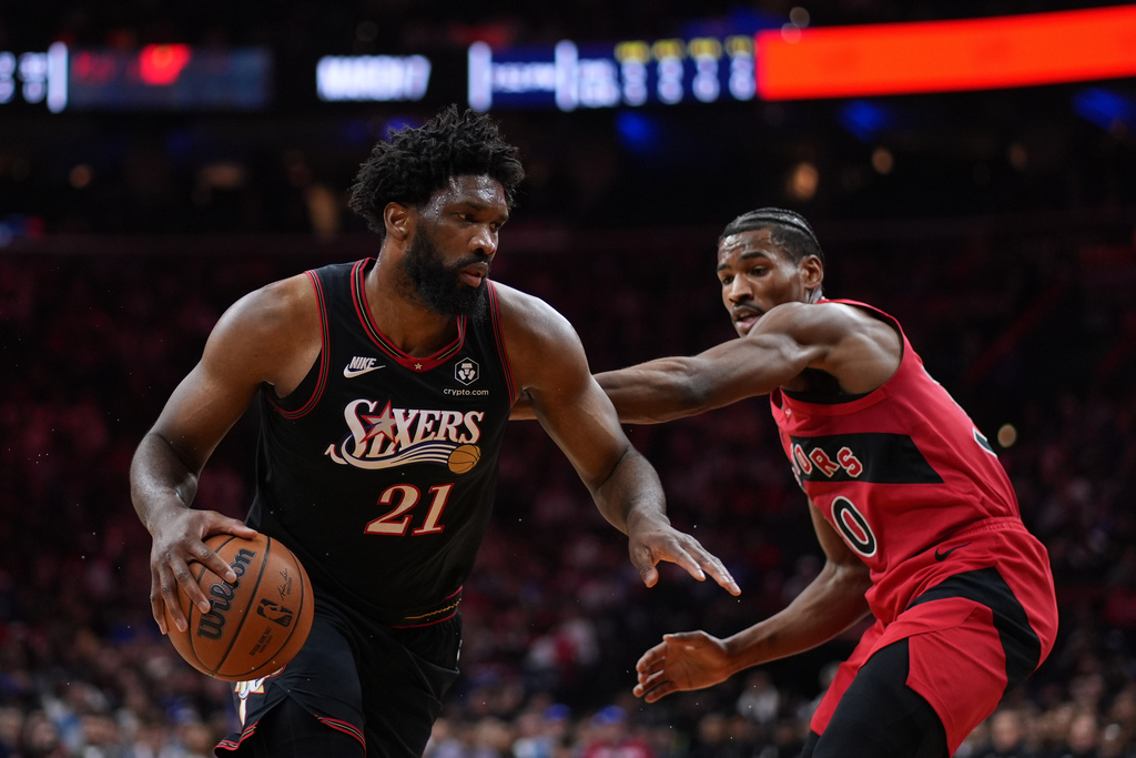 Philadelphia 76ers' Joel Embiid, left, tries to get past Toronto Raptors' Ochai Agbaji during the first half of an NBA basketball game Saturday, Nov. 8, 2025, in Philadelphia. (AP Photo/Matt Slocum)