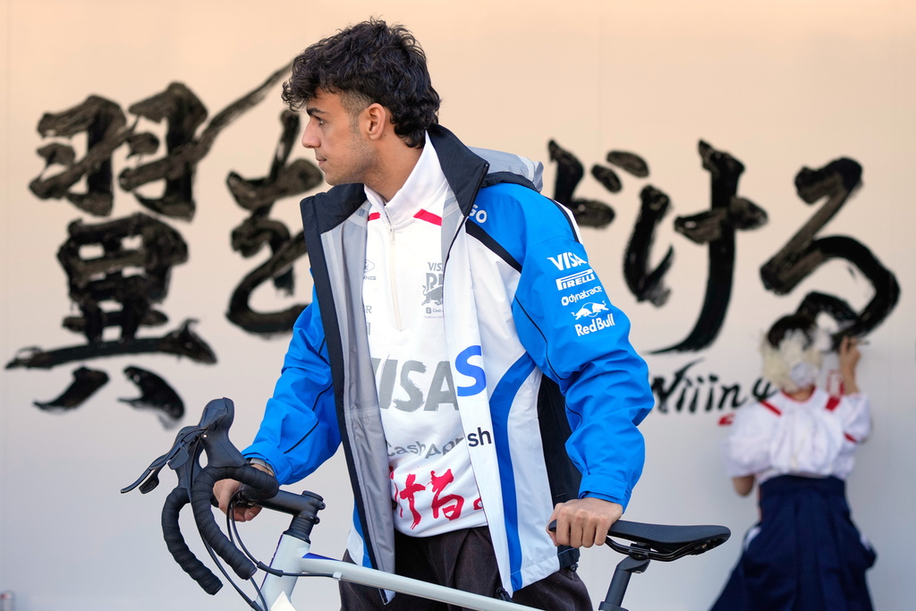 Racing Bulls driver Arvid Lindblad of Britain rides a bicycle ahead of the Japanese Formula One Grand Prix Thursday, March 26, 2026, in Suzuka, Central Japan. (AP Photo/Eugene Hoshiko)