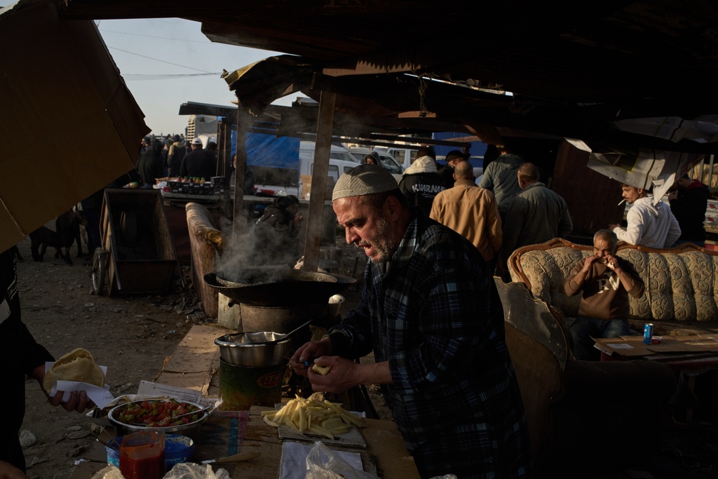 A Palestinian prepares falafel for sale at a livestock market near Balata refugee camp on the outskirts of the West Bank city of Nablus, Thursday, Feb. 12, 2026. (AP Photo/Leo Correa)