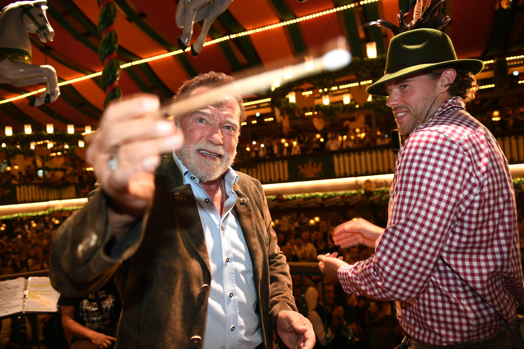 Arnold Schwarzenegger and his son, Christopher Schwarzenegger, stand on stage during the 190th Oktoberfest on Friday, Sept. 26, 2025, in Munich, Germany. (Felix Hörhager/dpa via AP)