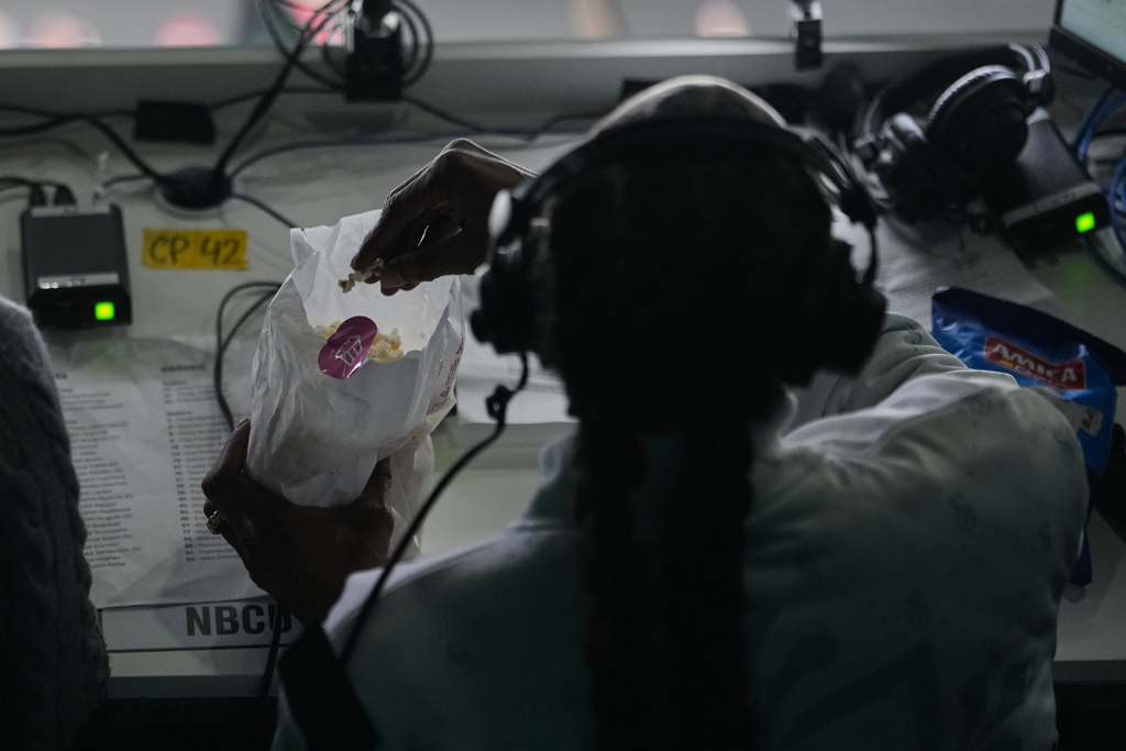 Snoop Dogg eats popcorn during the men's ice hockey quarterfinal game between the United States and Sweden at the 2026 Winter Olympics, in Milan, Italy, Wednesday, Feb. 18, 2026. (AP Photo/Carolyn Kaster)