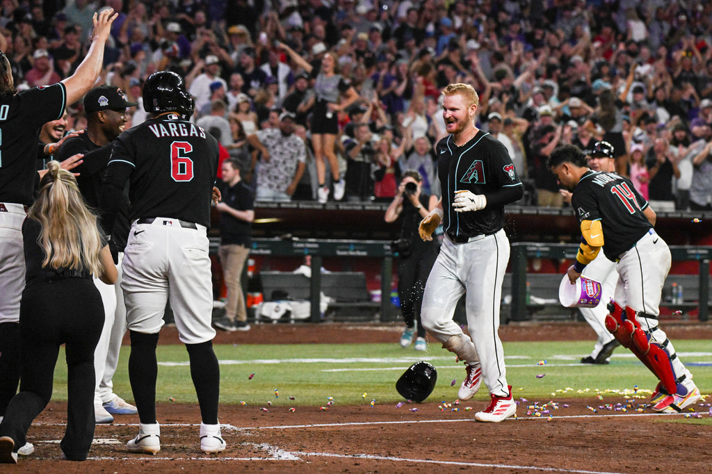Arizona Diamondbacks' Pavin Smith celebrates with the team as he arrives home after scoring the game-winning home run during the ninth inning of a baseball game against the New York Yankees, Saturday, Sept. 19, 2026, in Phoenix. (AP Photo/Caitlin O'Hara)