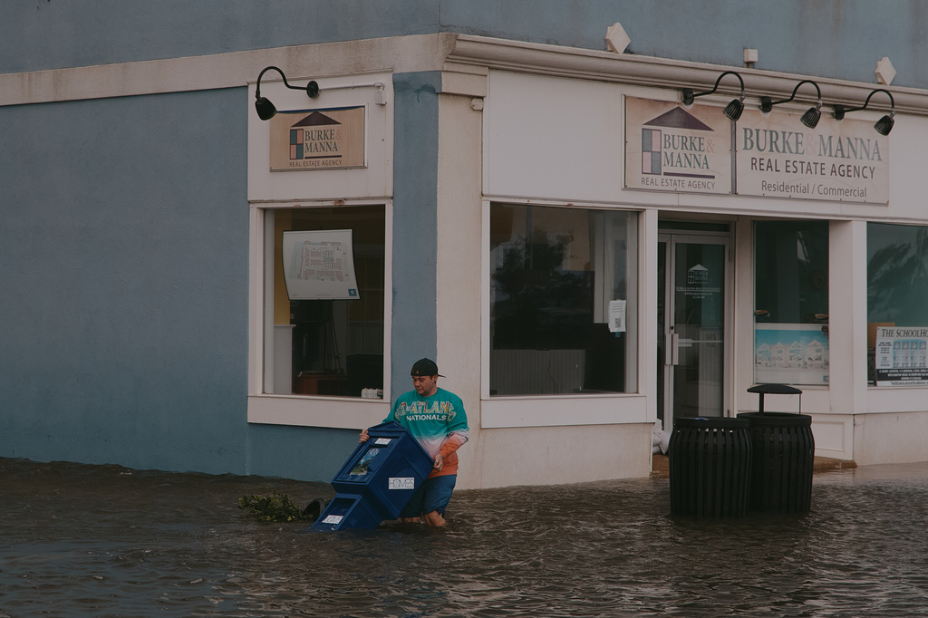 A man moves a bin through a flooded street during a nor'easter storm on Sunday, Sept. 27, 2026, in Sea Bright, N.J. (AP Photo/Andres Kudacki)