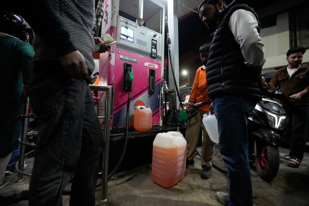 People store fuel in a plastic can at a petrol pump amid fears of a possible shortage due to the US Iran war, in Srinagar, Indian controlled Kashmir, Wednesday, March 25, 2026. (AP Photo/Mukhtar Khan)
