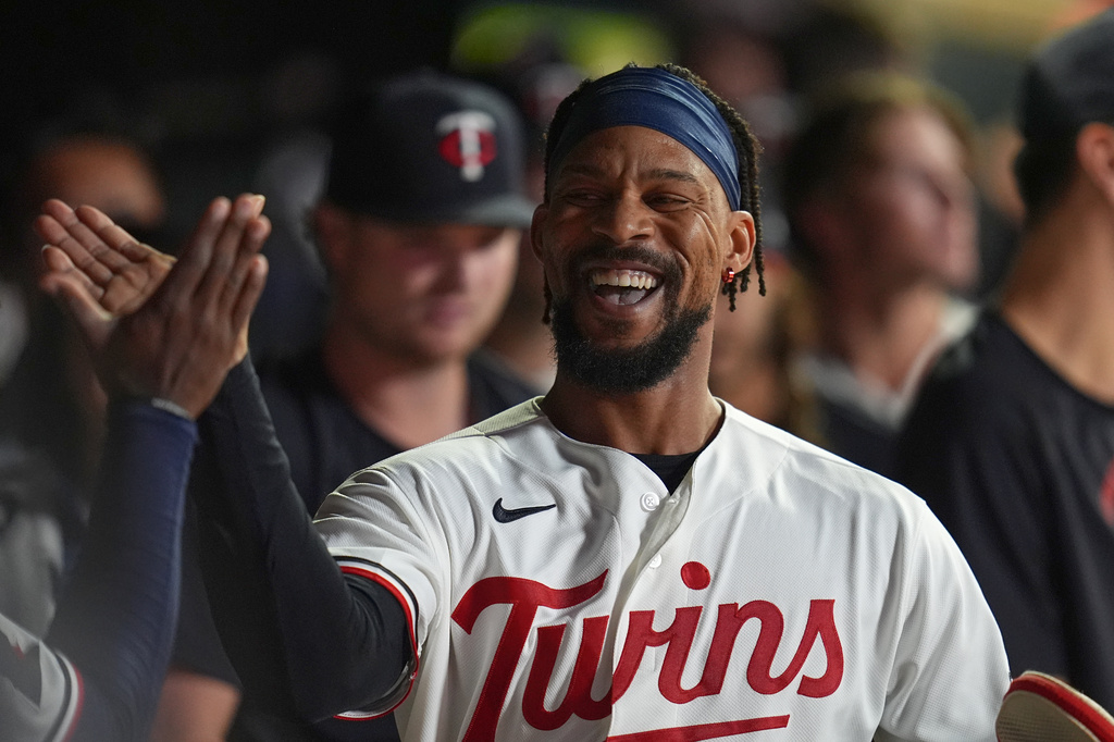 Minnesota Twins' Byron Buxton celebrates in the dugout after scoring off a 2-run double hit by Ryan Jeffers during the eighth inning of a baseball game against the Atlanta Braves Tuesday, Aug. 18, 2026, in Minneapolis. (AP Photo/Abbie Parr)