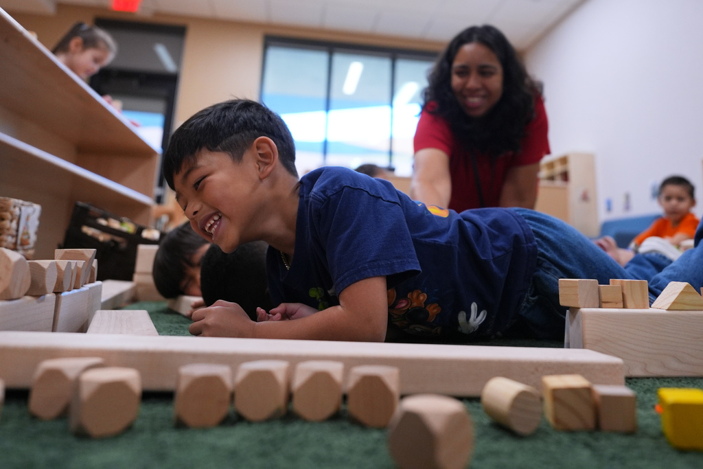 Pre-K 4 SA teacher Deziree Arce, center, plays a game with her students, Oct. 9, 2025, in San Antonio. (AP Photo/Eric Gay)