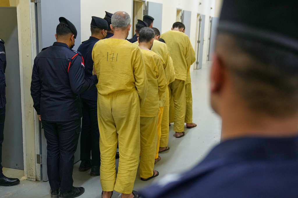 Iraqi security forces lead suspected Islamic State militants for questioning, after they were transferred from Syria to Iraq, at Al-Karkh Central Prison in Baghdad, Iraq, Thursday, Feb. 12, 2026. (AP Photo/Hadi Mizban)
