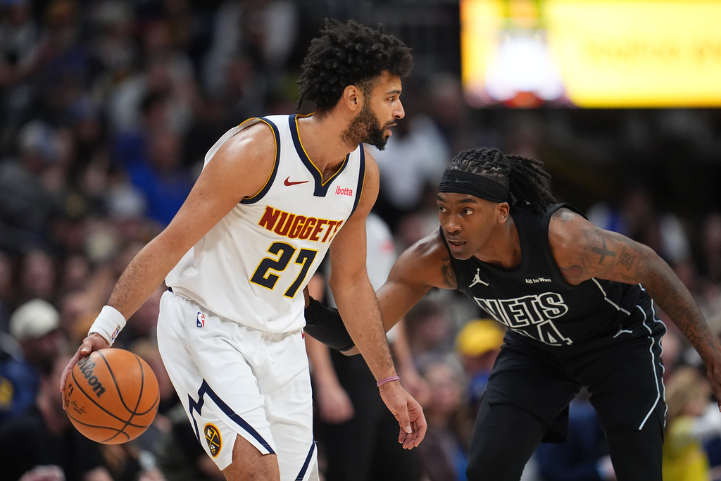 Denver Nuggets guard Jamal Murray, left, looks to drive to the rim as Brooklyn Nets guard Terance Mann defends in the first half of an NBA basketball game, Thursday, Jan. 29, 2026, in Denver. (AP Photo/David Zalubowski)