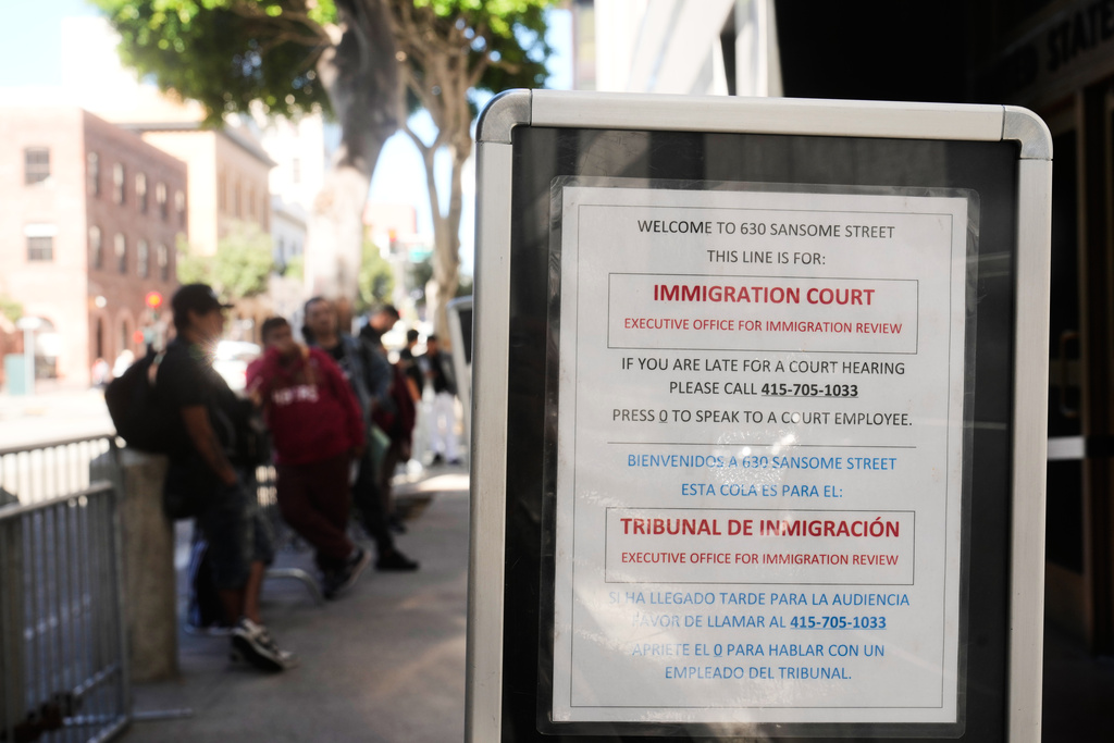 People wait in line outside Immigration Court on Tuesday, Oct. 21, 2025, in San Francisco. (AP Photo/Jeff Chiu)