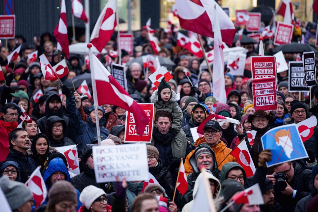 EDS NOTE: OBSCENITY - A crowd walks to the US consulate to protest against Trump's policy towards Greenland in Nuuk, Greenland, Saturday, Jan. 17, 2026. (AP Photo/Evgeniy Maloletka)
