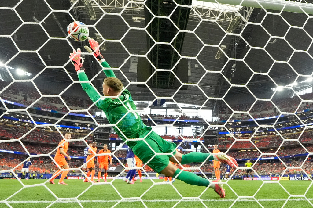Netherlands goalkeeper Bart Verbruggen (1) is beaten by a header from Japan's Daichi Kamada (15) for their second goal during the World Cup Group F soccer match between the Netherlands and Japan in Arlington, Texas, near Dallas, Sunday, June 14, 2026. (AP Photo/Tony Guttierez)