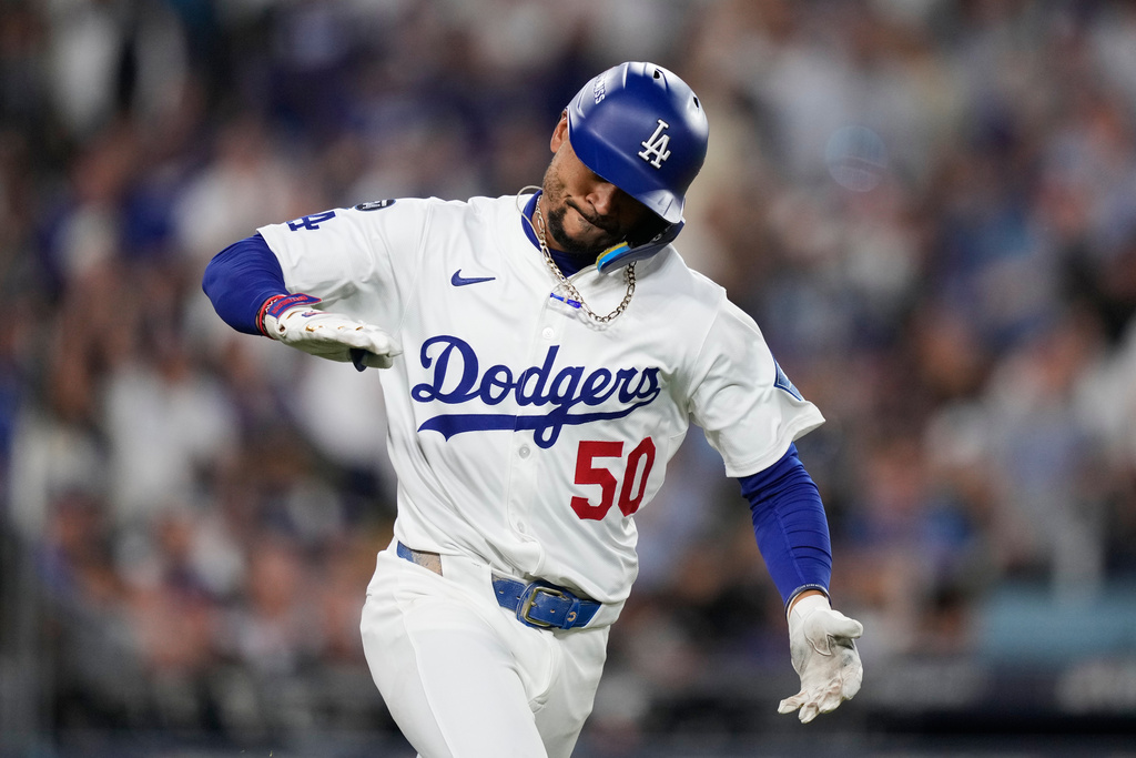 Los Angeles Dodgers' Mookie Betts reacts as he drives in a run with a single during the third inning in Game 2 of the National League Wild Card baseball playoff series against the Cincinnati Reds, Wednesday, Oct. 1, 2025, in Los Angeles. (AP Photo/Mark J. Terrill)