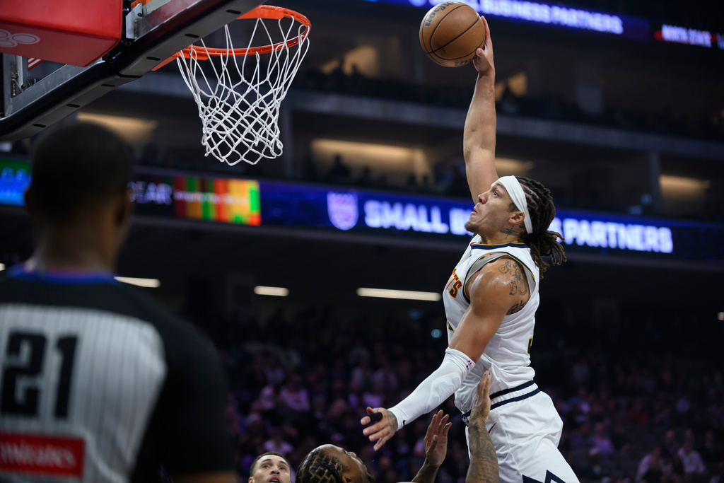 Denver Nuggets forward Aaron Gordon dunks over Sacramento Kings defenders during the first half of an NBA basketball game in Sacramento, Calif., Tuesday, Nov. 11, 2025. (AP Photo/Randall Benton)