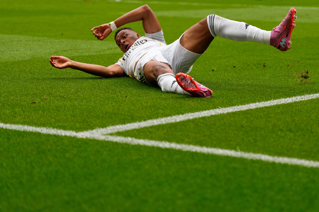Real Madrid's Kylian Mbappe falls as he battles for the ball during the Spanish La Liga soccer match between Atletico Madrid and Real Madrid at Metropolitano stadium, in Madrid, Spain, Saturday, Sept. 27, 2025. (AP Photo/Manu Fernandez)