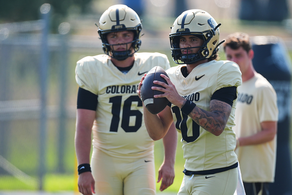 Colorado quarterback Julian Lewis takes part in a drioll as quasrtrback Isaac Wilson looks on during a practice at an NCAA college football training camp in Fountain, Colo., Thursday, Aug. 6, 2026. (AP Photo/David Zalubowski)