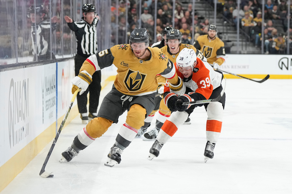 Vegas Golden Knights defenseman Jeremy Lauzon (5) skates with the puck against Philadelphia Flyers right wing Matvei Michkov (39) during the second period of an NHL hockey game Monday, Jan. 19, 2026, in Las Vegas. (AP Photo/Candice Ward)