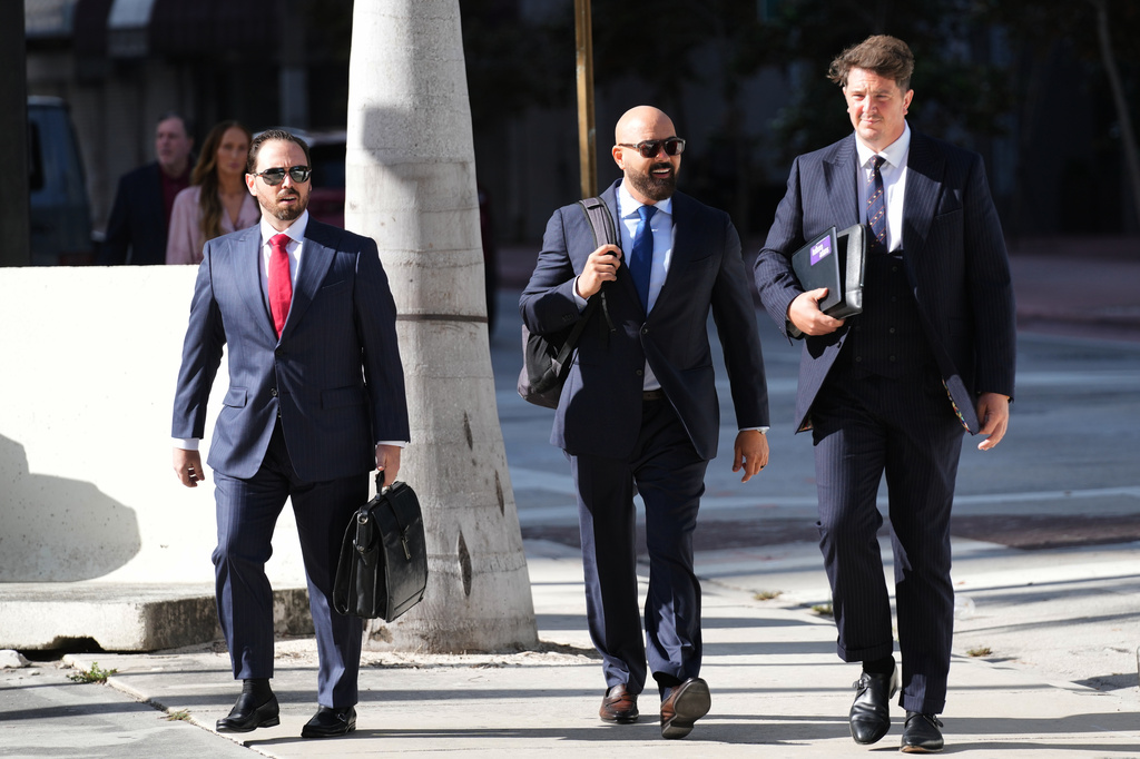 Attorneys Joseph McBride, center, and Andrew Ford, right, who represent Andrew and Tristan Tate as they fight extradition to the United Kingdom on charges of rape and sex trafficking, Thursday, Aug. 27, 2026, arrive for a bond hearing at the C. Clyde Atkins U.S. Courthouse, in Miami. (AP Photo/Lynne Sladky)