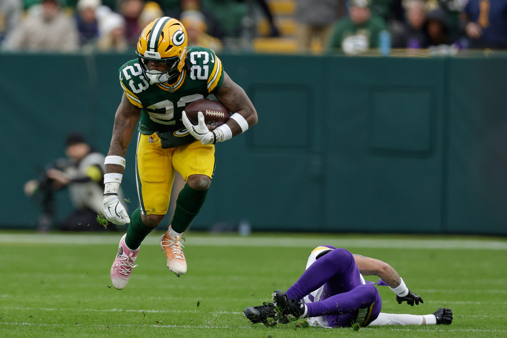 Green Bay Packers running back Emanuel Wilson (23) runs with the football after avoiding a tackle by Minnesota Vikings cornerback Byron Murphy (7), right, during the second half of an NFL football game Sunday, Nov. 23, 2025, in Green Bay, Wis. (AP Photo/Matt Ludtke)