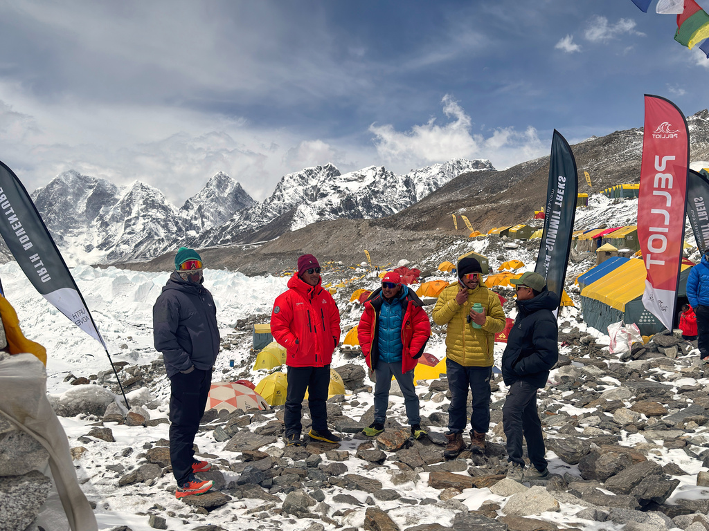 Guides and mountaineers stand outside their tents during acclimatization period before attempting the Mount Everest ascent at the base camp, Nepal, Sunday, May 10, 2026. (AP Photo/Pasang Rinzee Sherpa)