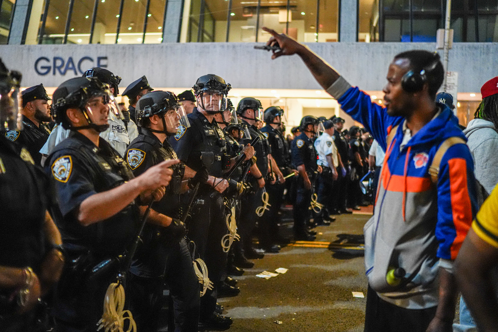 NYPD officers push New York Knicks fans back outside of a watch party in Bryant Park for Game 3 of the NBA Finals basketball series between the Knicks and the San Antonio Spurs, Monday, June 8, 2026, in New York. (AP Photo/Ryan Murphy)
