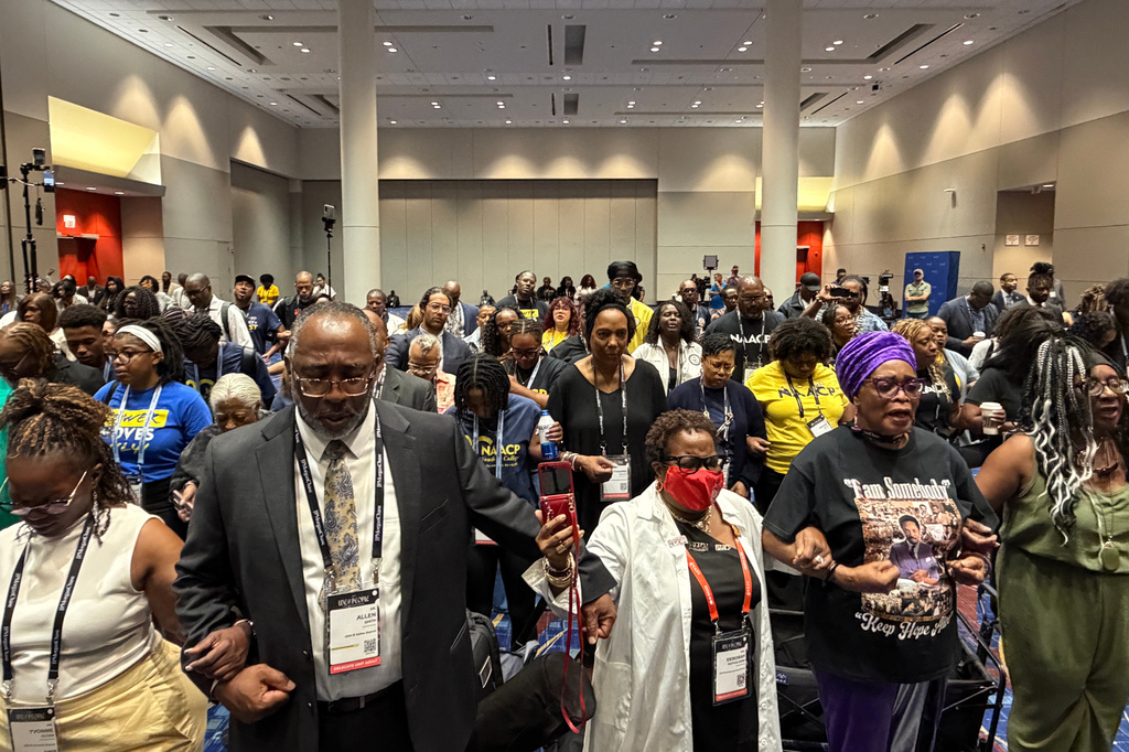 Attendees join hands in prayer at a news conference about the results of an independent autopsy of Nolan Wells at the NAACP National Convention in Chicago, Wednesday, July 22, 2026. (AP Photo/Laura Bargfeld)