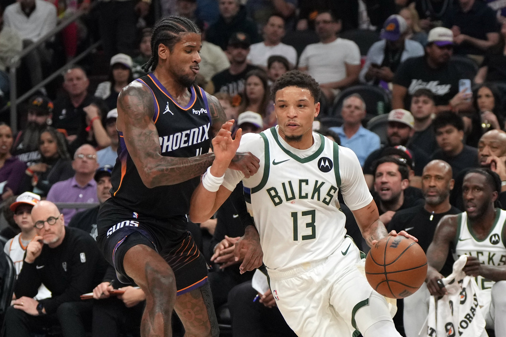 Milwaukee Bucks guard Ryan Rollins (13) drives on Phoenix Suns guard Jalen Green during the first half of an NBA basketball game, Saturday, March 21, 2026, in Phoenix. (AP Photo/Rick Scuteri)