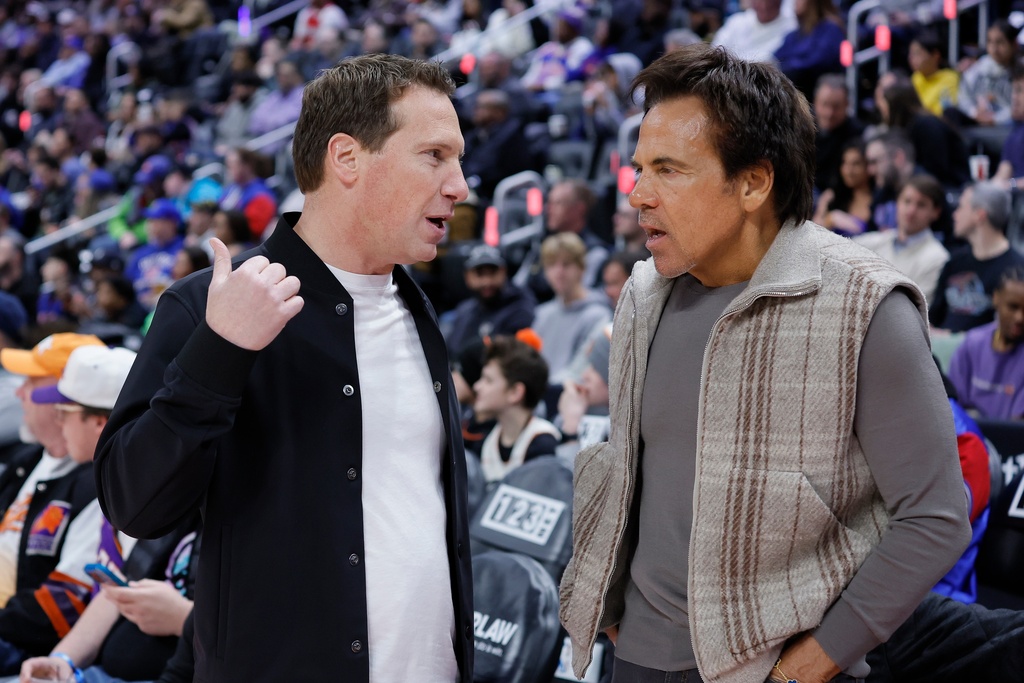 Phoenix Suns owner Mat Ishbia, left, talks with Detroit Pistons owner Tom Gores during the first half of an NBA basketball game, Thursday, Jan. 15, 2026, in Detroit. (AP Photo/Duane Burleson)