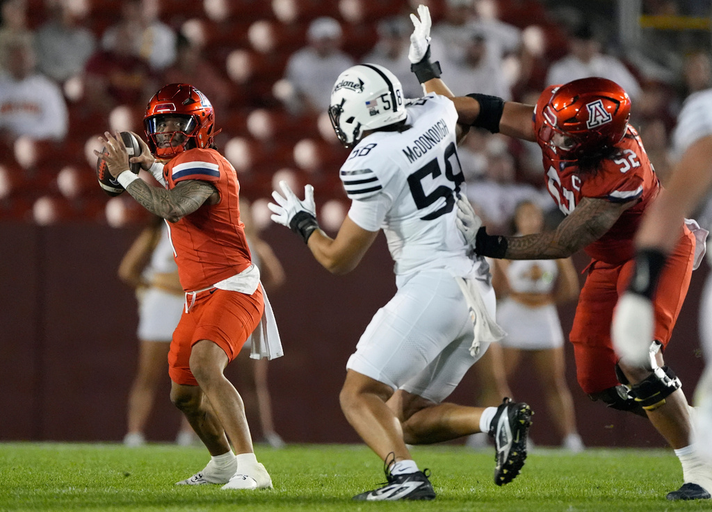 Iowa State defensive lineman Tamatoa McDonough (58) applies pressure to Arizona quarterback Noah Fifita (1) as offensive lineman Ka'ena Decambra (52) defends during the second half of an NCAA college football game, Saturday, Sept. 27, 2025, in Ames, Iowa. (AP Photo/Matthew Putney)