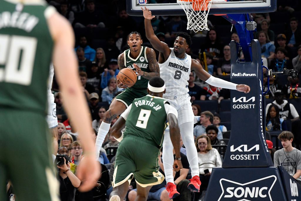 Milwaukee Bucks guard Kevin Porter Jr. handles the ball against Memphis Grizzlies forward Jaren Jackson Jr. (8) in the first half of an NBA basketball game, Friday, Dec. 26, 2025, in Memphis, Tenn. (AP Photo/Brandon Dill)