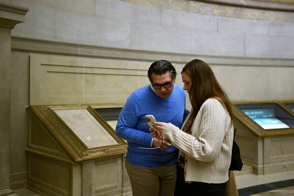 Ryan O'Neil, left, and Kate Weaver of West Bloomfield, Mich., look at a photo that they took of the Bill of Rights during their visit to the National Archives Thursday, Jan. 29, 2026, in Washington. (AP Photo/John McDonnell)