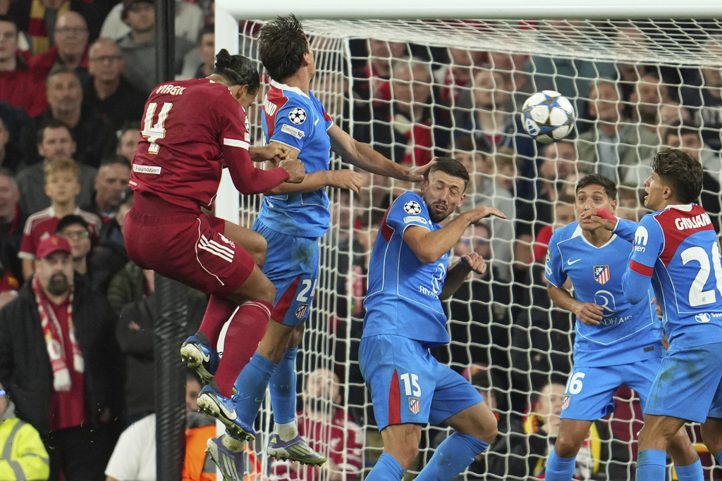 Liverpool's Virgil van Dijk, left, scores his side's third goal during the Champions League opening phase soccer match between Liverpool and Atletico Madrid at Anfield stadium in Liverpool, England, Wednesday, Sept. 17, 2025. (AP Photo/Jon Super)