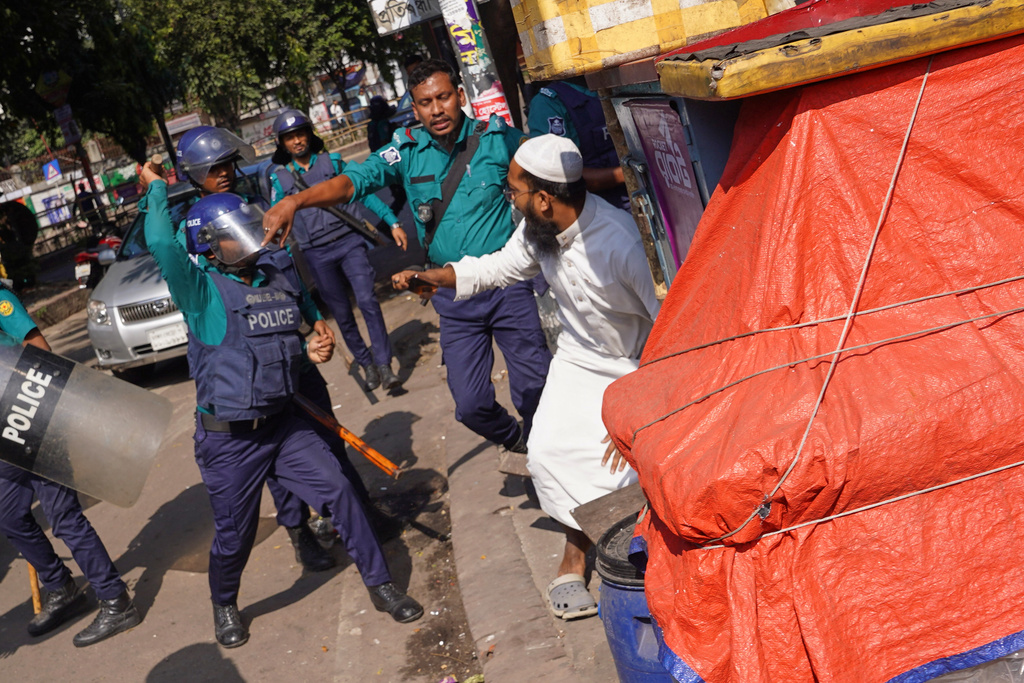 Police use baton to disperse protesters gather outside the demolished residence of Sheikh Mujibur Rahman, Bangladesh's former leader and the father of the country's ousted Prime Minister Sheikh Hasina ahead of an expected verdict against Hasina, in Dhaka, Bangladesh, Monday, Nov. 17, 2025. (AP Photo/ Ahadul Karim Khan)
