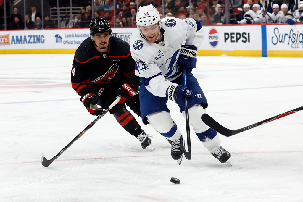 Tampa Bay Lightning's Brayden Point (21) controls the puck in front of Carolina Hurricanes' Seth Jarvis (24) during the first period of an NHL hockey game in Raleigh, N.C., Thursday, Feb. 26, 2026. (AP Photo/Karl DeBlaker)