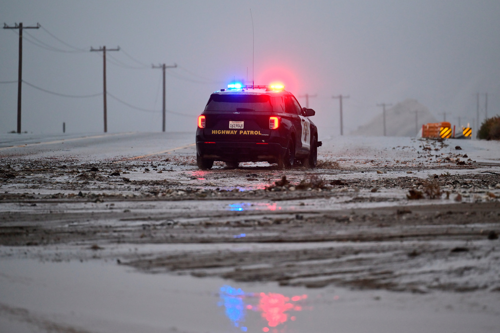 A California Highway Patrol officer drives along California State Route 138 through mud Wednesday, Dec. 24, 2025, near Wrightwood, Calif. (AP Photo/Wally Skalij)