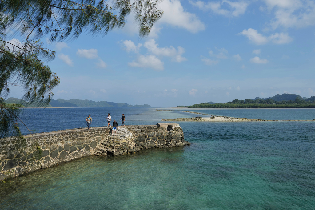 People walk at KB Bridge Beach as the Pacific Islands Forum Leaders Meeting takes place in Koror, Palau, Sunday, Aug. 30, 2026. (AP Photo/Charlotte Graham-McLay)