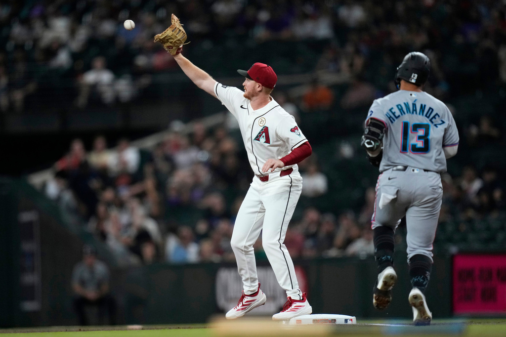 Arizona Diamondbacks first baseman Pavin Smith, left, makes a catch at first base to get Miami Marlins' Heriberto Hernández (13) out during the first inning of a baseball game, Tuesday, Sept. 15, 2026, in Phoenix. (AP Photo/Ross D. Franklin)
