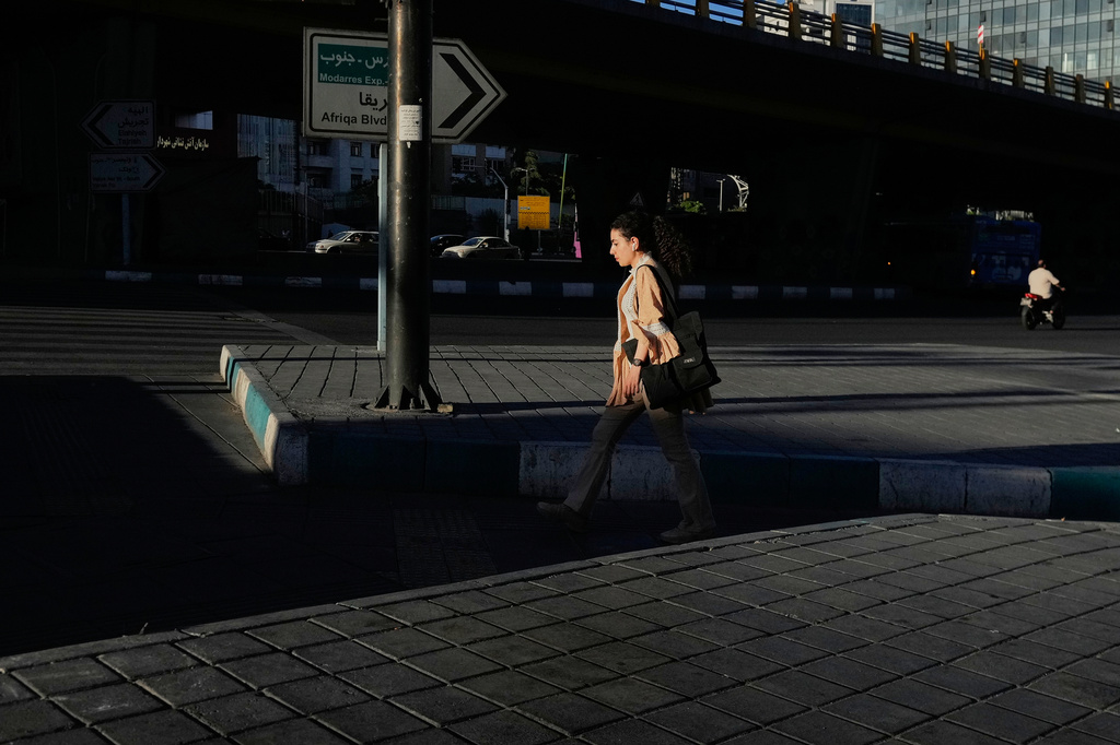 A woman crosses an intersection in northern Tehran, Iran, Tuesday, May 26, 2026. (AP Photo/Vahid Salemi)
