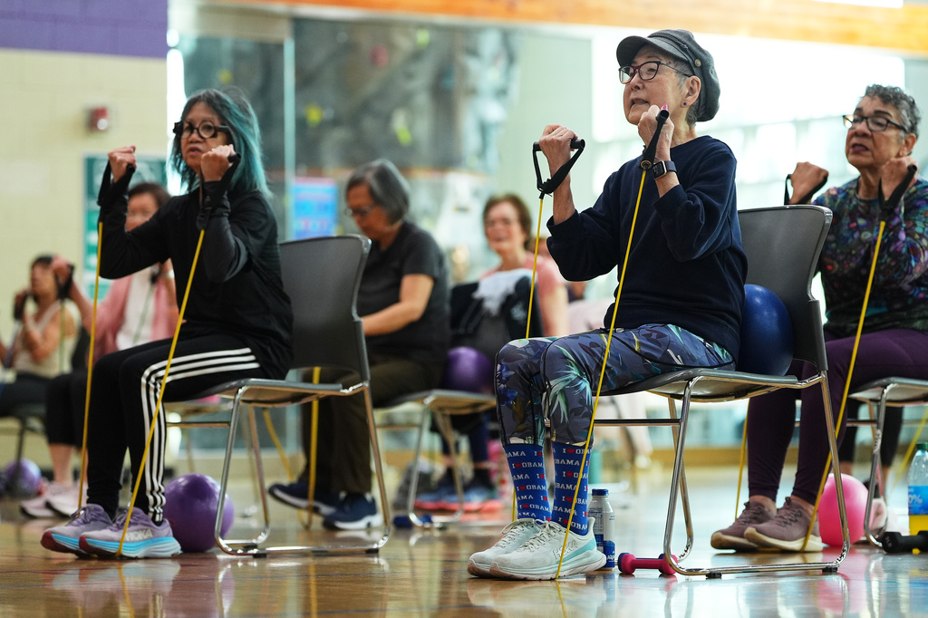 Ann Kashiwa, 91, right, uses an exercise band while taking a class for older adults led by instructor Bengie Santos at the Dale Turner Family YMCA, April 30, 2026, in Shoreline, Wash. (AP Photo/Lindsey Wasson)