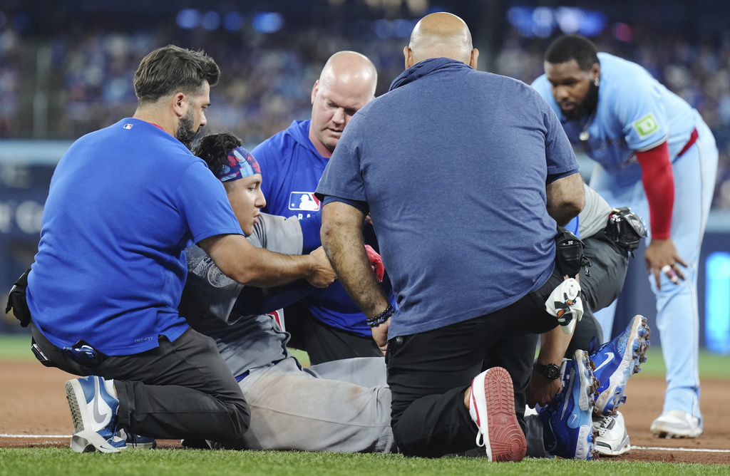 Chicago Cubs catcher Miguel Amaya (9) is tended to by medical staff and leaves the game during eighth inning MLB baseball action against the Toronto Blue Jays in Toronto on Wednesday, August 13, 2025. (Nathan Denette/The Canadian Press via AP)
